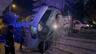 Sürücü fren yerine gaza basınca beton korkulukları yıkan araç bahçe duvarında asılı kaldı